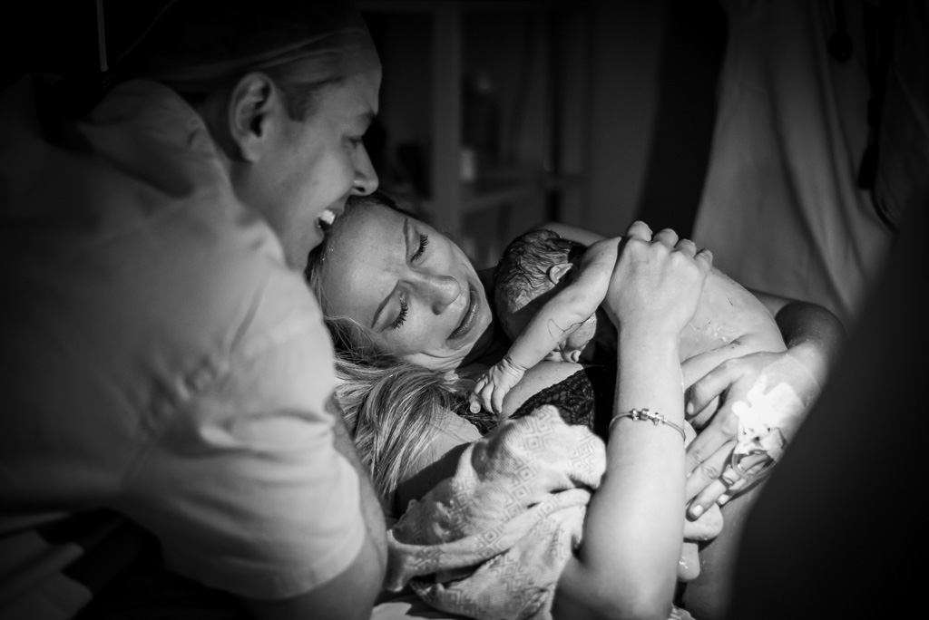 Mãe segurando seu bebê no colo assim que nasceu após seu parto parto normal, natural e humanizado